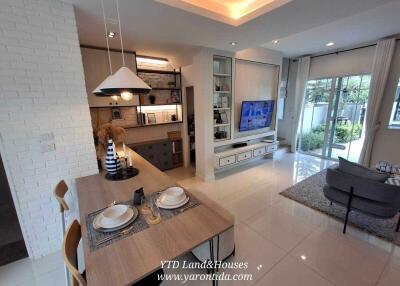 Modern living room and dining area with large TV and kitchen access