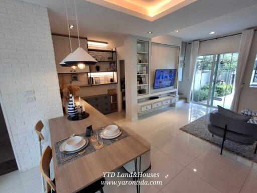 Modern living room and dining area with large TV and kitchen access