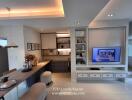 Modern living area with built-in TV unit, workspace, and dining corner