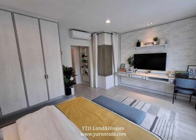 spacious bedroom with built-in wardrobe, modern decor and wall-mounted TV