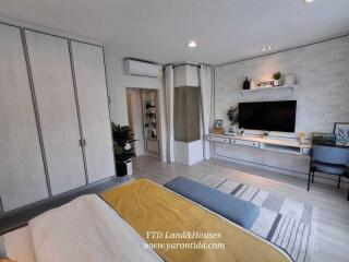 spacious bedroom with built-in wardrobe, modern decor and wall-mounted TV