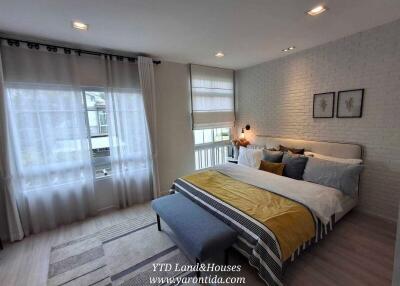 Modern bedroom with double bed, large windows, and decorative accents