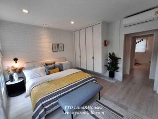 Spacious bedroom with white brick wall, modern furniture, and cozy decor