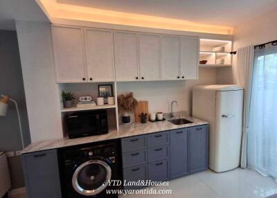 Modern kitchen with white cabinets, gray lower cabinets, and retro refrigerator