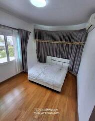 Cozy bedroom with a large window and wooden floor