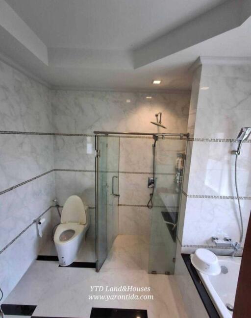 Modern bathroom with glass-enclosed shower and marble-like walls