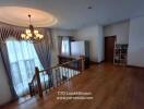 Well-lit living area with chandelier and wooden flooring