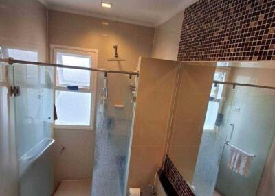 Modern bathroom with glass shower enclosure and mosaic tile accents