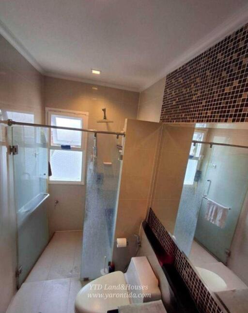 Modern bathroom with glass shower enclosure and mosaic tile accents