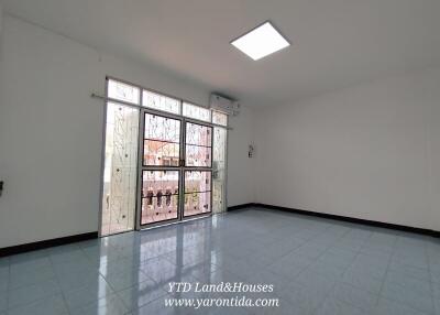 Spacious living room with large window and tiled floor