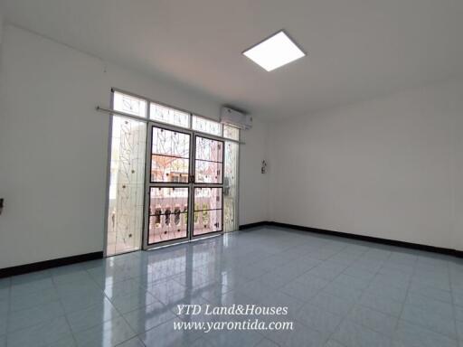 Spacious living room with large window and tiled floor