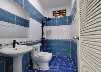 Modern blue-tiled bathroom with a shower and white fixtures