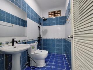 Modern blue-tiled bathroom with a shower and white fixtures