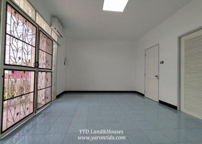 Spacious living room with large window and tiled flooring