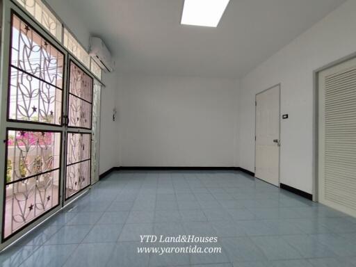 Spacious living room with large window and tiled flooring