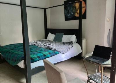 Cozy bedroom with a four-poster bed and laptop workspace