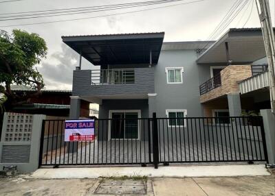 Exterior view of a two-story house with a for sale sign