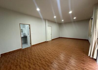 Spacious living room with tiled floor, recessed lighting, and attached bathroom