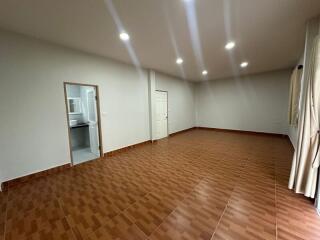 Spacious living room with tiled floor, recessed lighting, and attached bathroom