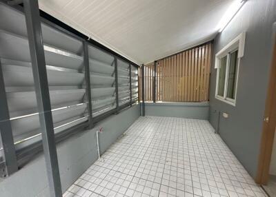 Enclosed patio with tiled flooring and louvered windows