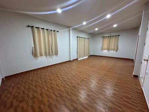 Spacious living room with tiled floor and curtained windows