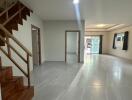 Spacious living room with staircase and large windows