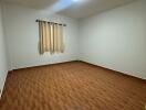 Empty bedroom with tiled floor and window with curtains