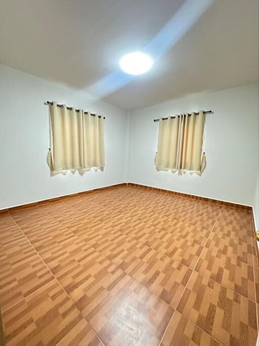 Empty bedroom with tiled floor and curtains