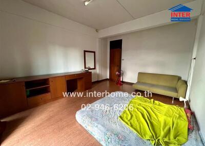 Bedroom with wooden furniture, bed, and couch