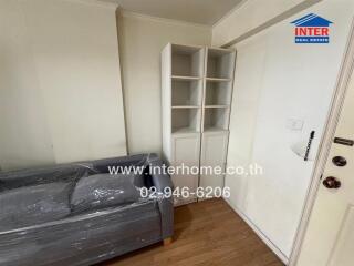 Living room with a grey sofa and a white bookshelf