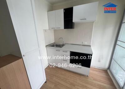 Compact kitchen with white cabinetry and a sink