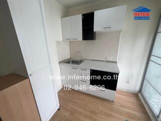 Compact kitchen with white cabinetry and a sink