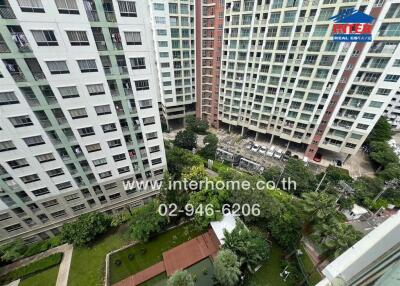 View from above of a residential complex with multiple high-rise buildings surrounding a garden area