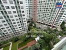 View from above of a residential complex with multiple high-rise buildings surrounding a garden area