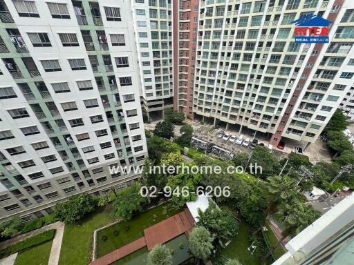 View from above of a residential complex with multiple high-rise buildings surrounding a garden area