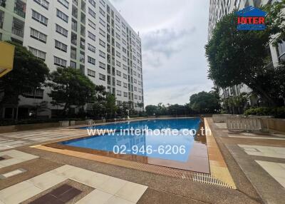 Outdoor pool area with apartment buildings in the background