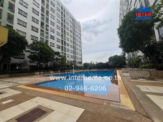 Outdoor pool area with apartment buildings in the background