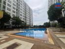 Outdoor pool area with apartment buildings in the background