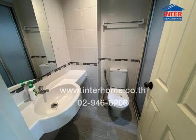 Compact bathroom with modern fixtures and tiled walls