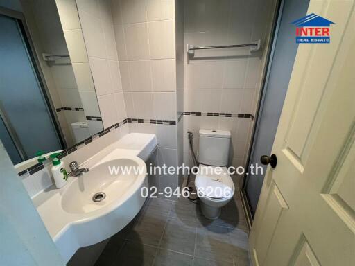 Compact bathroom with modern fixtures and tiled walls