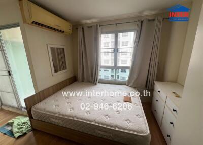 Bedroom with double bed, air conditioning, large window, and storage