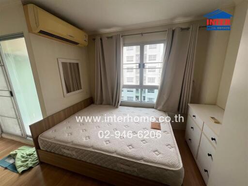 Bedroom with double bed, air conditioning, large window, and storage