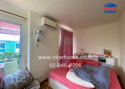 Bedroom with pink bed, wall-mounted air conditioner, and a window with a view