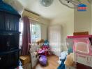 Small cluttered bedroom with storage boxes and a mattress against the wall