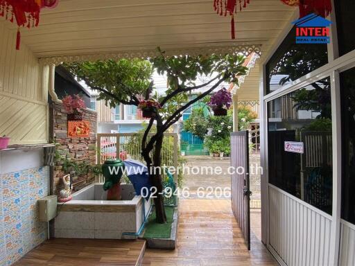 Covered outdoor space with plants and a small garden