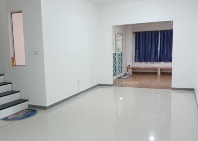 Spacious living room with white walls and glossy floor tiles