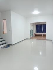 Spacious living room with white walls and glossy floor tiles