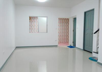 Bright spacious living area with tiled floor and adjacent rooms