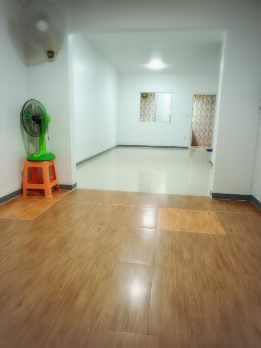 Spacious living room with a fan and wooden flooring