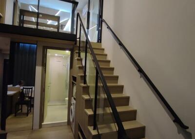 Interior of a modern loft with a staircase leading to a mezzanine level